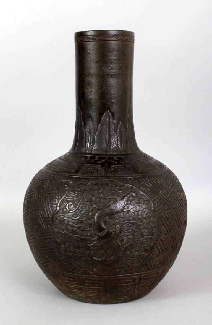 A LARGE 19TH CENTURY CHINESE IMITATION BRONZE MOULDED: A LARGE 19TH CENTURY CHINESE IMITATION BRONZE MOULDED PORCELAIN BOTTLE VASE, the sides decorated with barbed panels of dragons amidst cloud scrolls, the panels reserved on a linked wan swastika ground