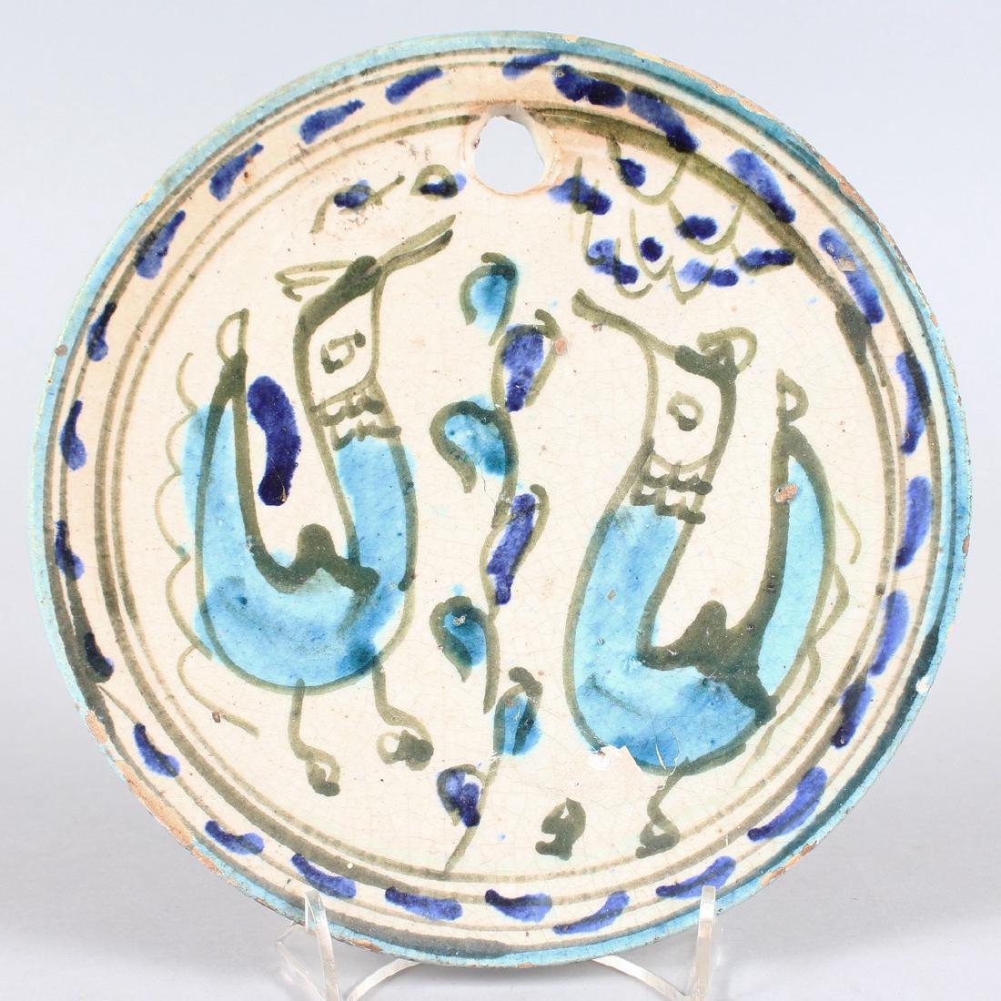 A FAIENCE CIRCULAR POTTERY WALL PLAQUE decoration with: A FAIENCE CIRCULAR POTTERY WALL PLAQUE decoration with two birds. 8.25ins diameter.
