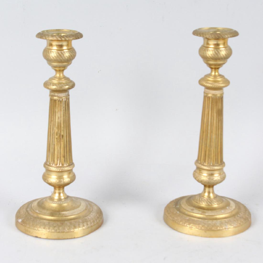 A PAIR OF LOUIS XVIth ORMOLU CIRCULAR CANDLESTICKS: A PAIR OF LOUIS XVIth ORMOLU CIRCULAR CANDLESTICKS with fluted stems on a circular base. 9ins high.