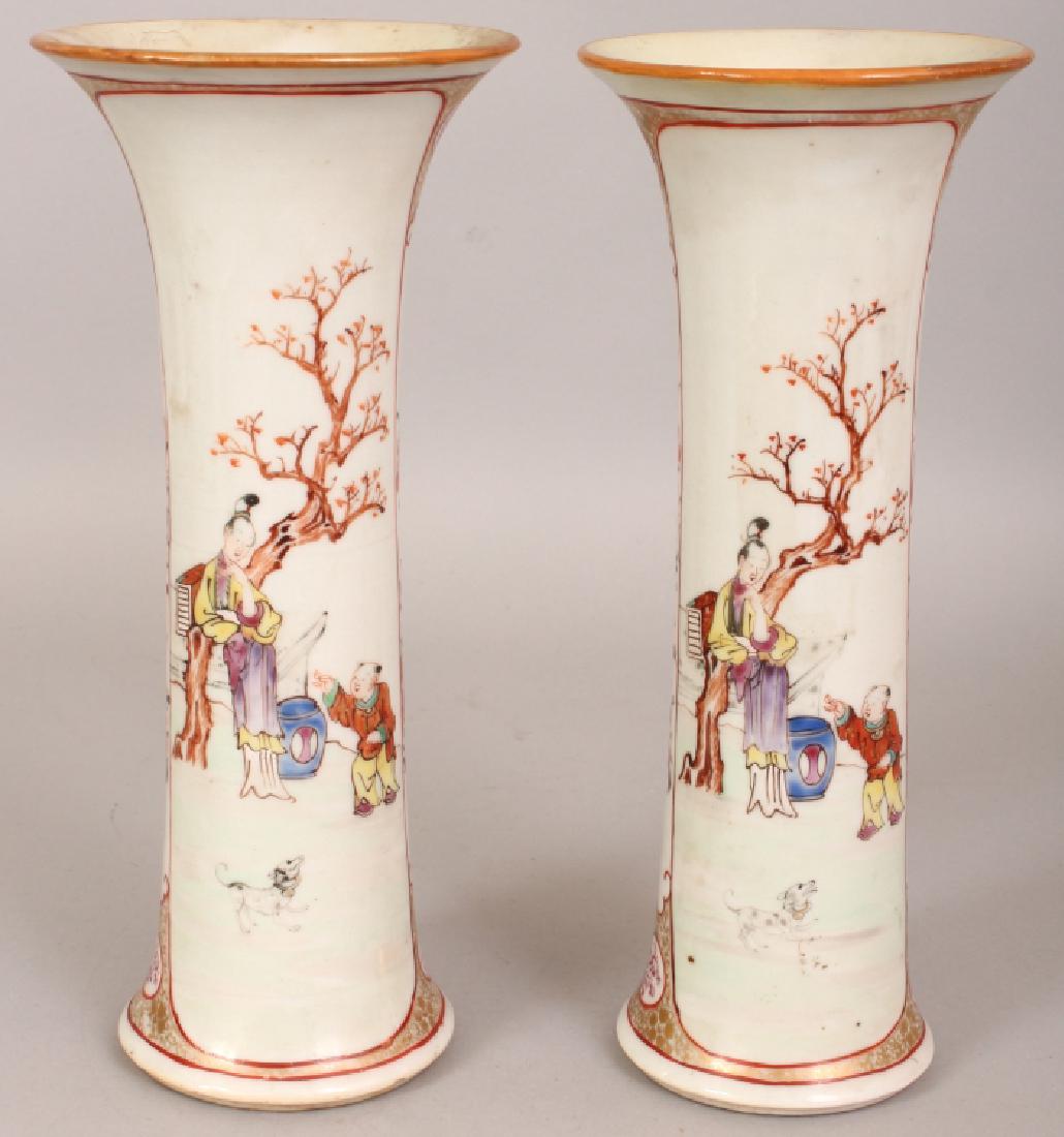 A PAIR OF 18TH CENTURY CHINESE QIANLONG PERIOD FAMILLE: A PAIR OF 18TH CENTURY CHINESE QIANLONG PERIOD FAMILLE ROSE MANDARIN PALETTE PORCELAIN BEAKER VASES, each well painted with panels of ladies and boys in garden settings, 9.6in high.