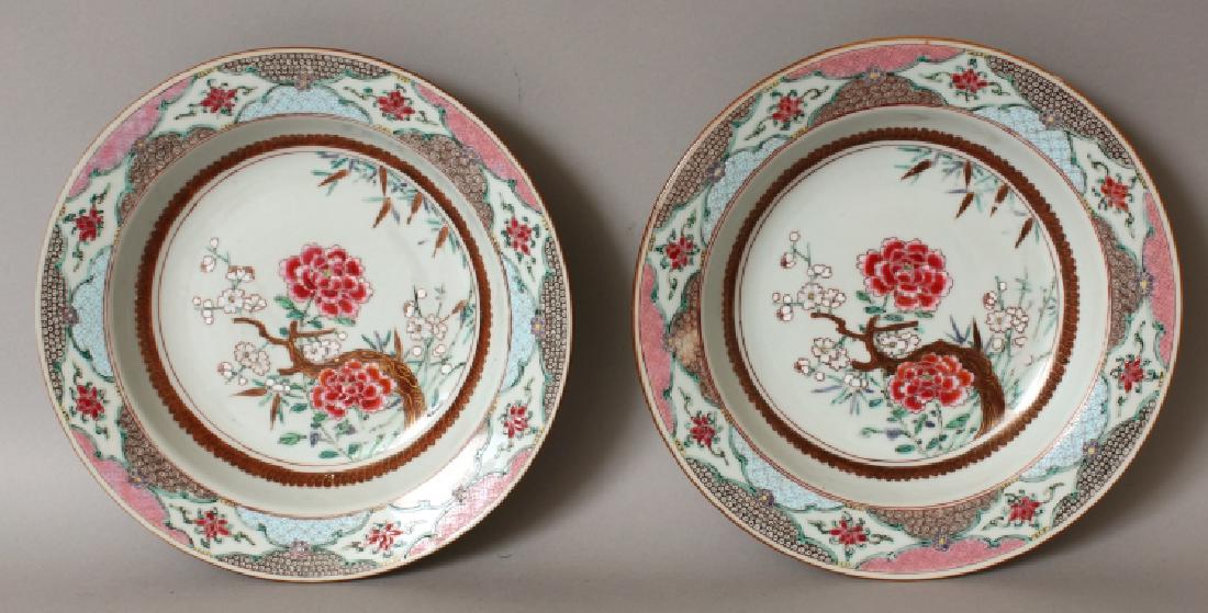 A GOOD PAIR OF CHINESE YONGZHENG PERIOD FAMILLE ROSE: A GOOD PAIR OF CHINESE YONGZHENG PERIOD FAMILLE ROSE PORCELAIN SOUP PLATES, circa 1730, each interior well painted with plum blossom, peony and bamboo, each flanged rim with lotus vignettes reserved o