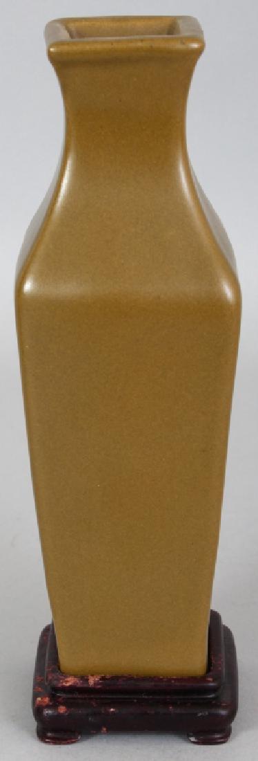 A CHINESE TEA DUST SQUARE SECTION PORCELAIN VASE,: A CHINESE TEA DUST SQUARE SECTION PORCELAIN VASE, together with a fitted wood stand, the glaze evenly applied, 8.5in high overall, the vase itself 7.75in high.