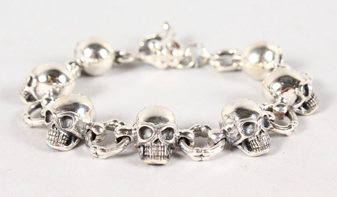 A SILVER NOVELTY SKULL AND BONE BRACELET.: A SILVER NOVELTY SKULL AND BONE BRACELET.