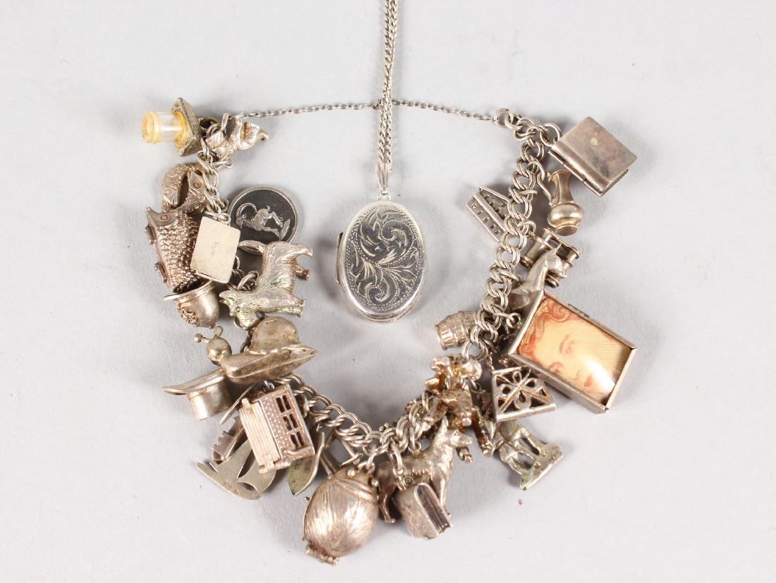 A SILVER CHARM BRACELET and a locket and chain.: A SILVER CHARM BRACELET and a locket and chain.
