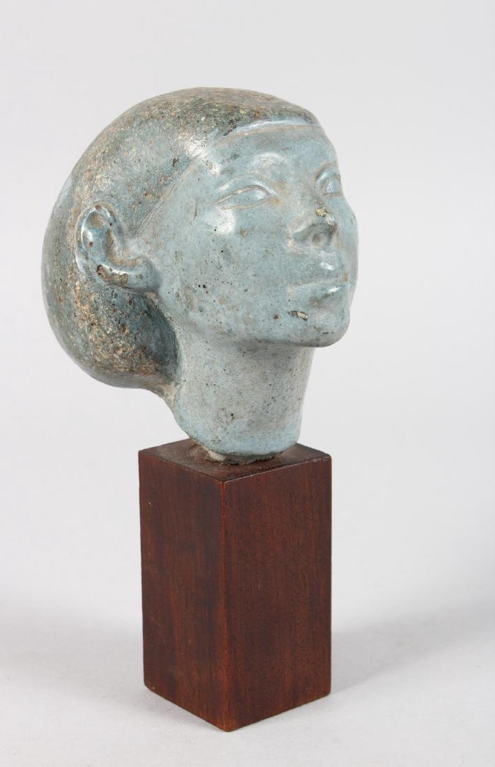 AN ANCIENT EGYPTIAN CARVED GREY MARBLE BUST. 4ins: AN ANCIENT EGYPTIAN CARVED GREY MARBLE BUST. 4ins high, on a wooden plinth.