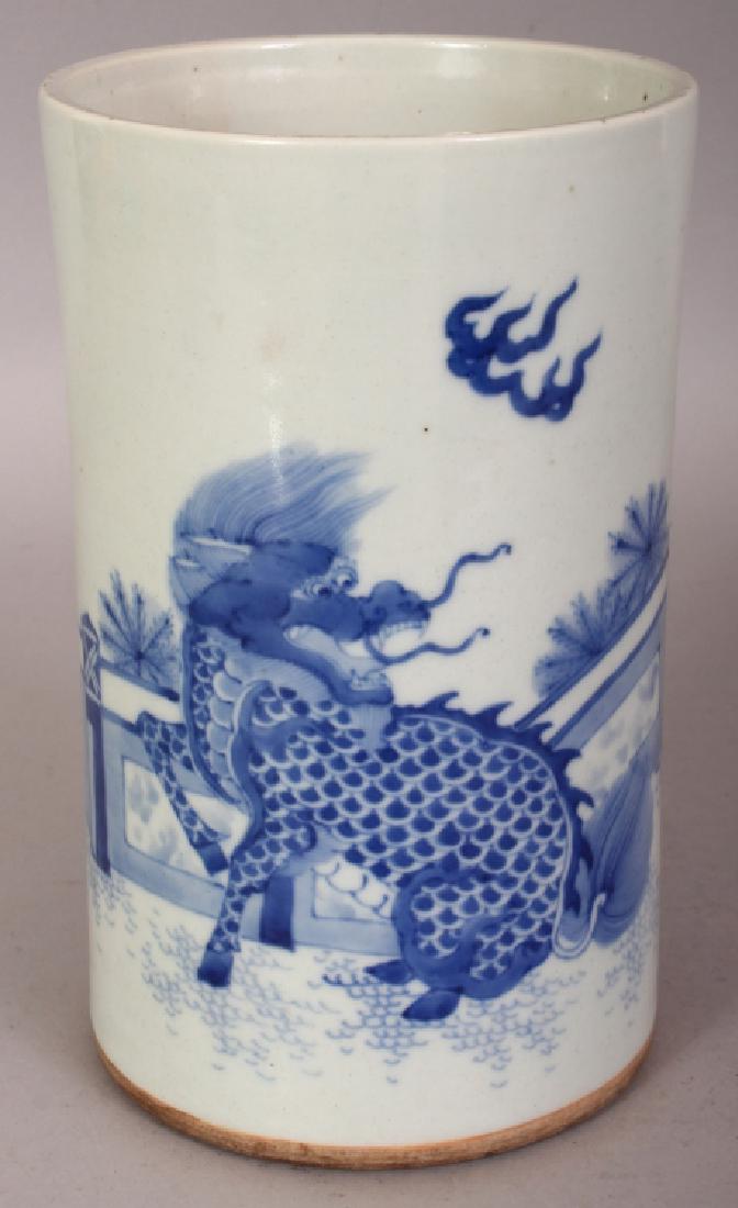 A CHINESE BLUE & WHITE TRANSITIONAL STYLE PORCELAIN: A CHINESE BLUE & WHITE TRANSITIONAL STYLE PORCELAIN BRUSHPOT, decorated with a kylin in a fenced garden setting, the base unglazed, 4.7in diameter at base & 7.9in high.