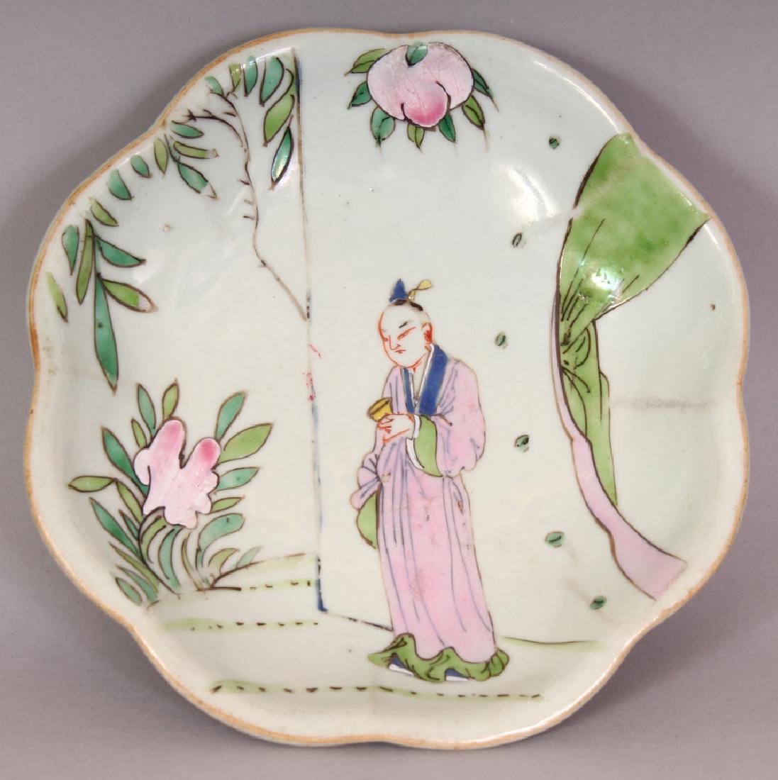 A LATE 19TH CENTURY CHINESE FAMILLE ROSE OCTOFOIL: A LATE 19TH CENTURY CHINESE FAMILLE ROSE OCTOFOIL PORCELAIN FOOTED DISH, the interior painted with a standing figure in a garden terrace setting, the foot with waves, 6.3in wide at widest point.