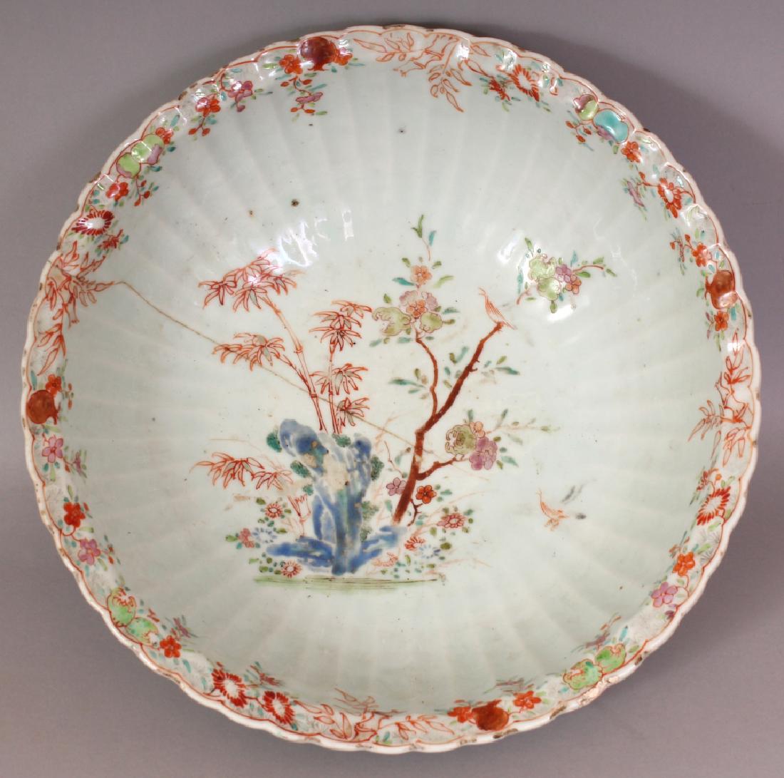 AN 18TH CENTURY CHINESE QIANLONG PERIOD FAMILLE ROSE: AN 18TH CENTURY CHINESE QIANLONG PERIOD FAMILLE ROSE FLUTED PORCELAIN BOWL, the deep interior painted with a garden scene, 11.5in diameter & 3.7in high.
