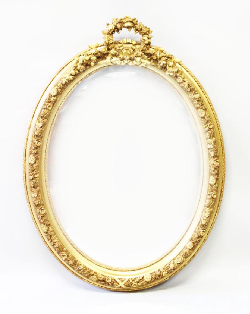 A DECORATIVE OVAL GILT FRAMED MIRROR, 20TH CENTURY,: A DECORATIVE OVAL GILT FRAMED MIRROR, 20TH CENTURY, with ribbon work cresting. 3ft 7ins high x 2ft 5ins wide.
