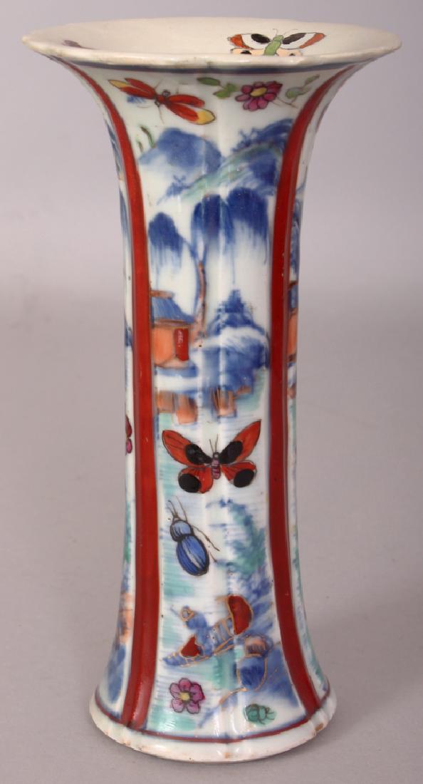 AN 18TH CENTURY CHINESE CLOBBERED PORCELAIN BEAKER: AN 18TH CENTURY CHINESE CLOBBERED PORCELAIN BEAKER VASE, with fluted sides and painted with panels of river landscape settings, 7in high.
