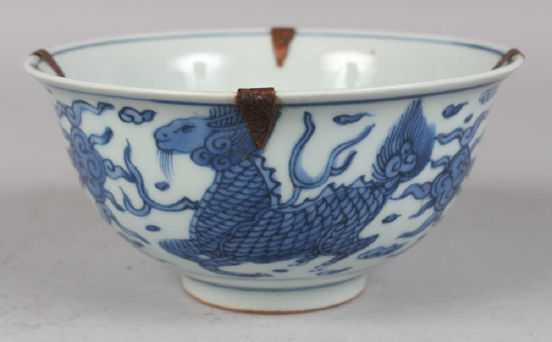 A CHINESE WANLI STYLE BLUE & WHITE PORCELAIN BOWL,: A CHINESE WANLI STYLE BLUE & WHITE PORCELAIN BOWL, decorated with auspicious characters, mythical animals and cloud scrolls, the rim with metal fittings, the base with a six-character Wanli mark, 6in 