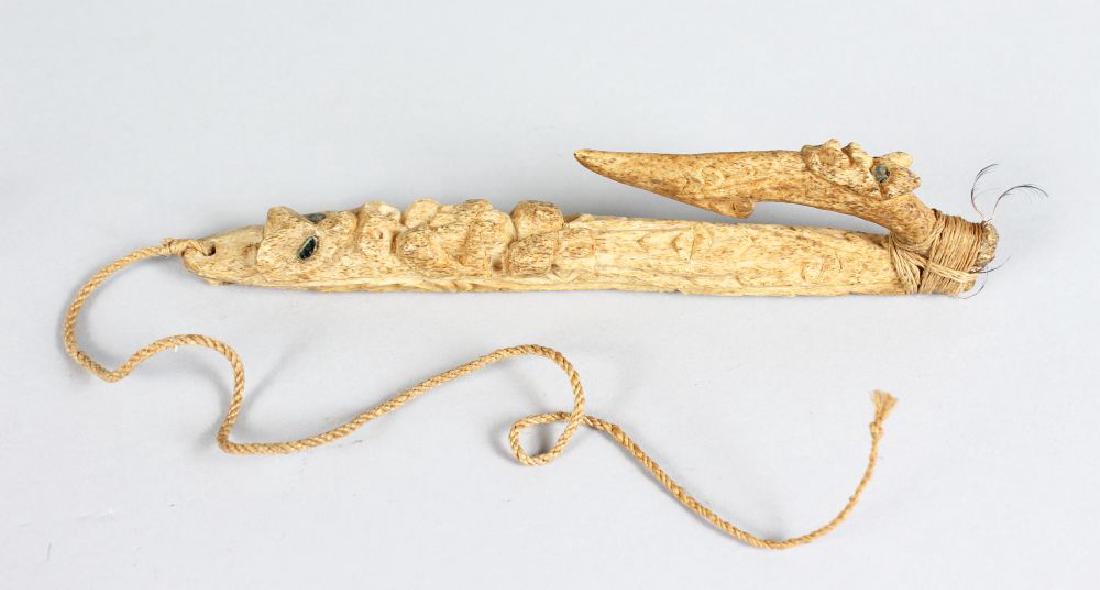 MAORI FISH HOOK, NEW ZEALAND Matau An extensively: MAORI FISH HOOK, NEW ZEALAND Matau An extensively carved bone, glass inset mirrored eyes to the figure and barb, the barb fixed at the base and bound tightly again with muka (flax fibre) cord. Height 