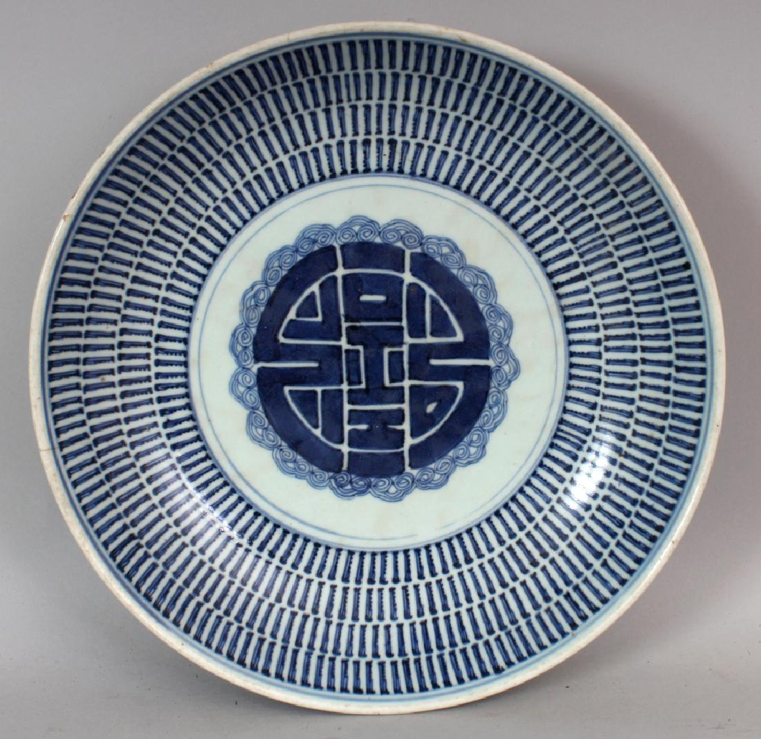 AN 18TH/19TH CENTURY CHINESE BLUE & WHITE PROVINCIAL: AN 18TH/19TH CENTURY CHINESE BLUE & WHITE PROVINCIAL PORCELAIN DISH, of saucer shape, painted to its centre with a Shou medallion, 11.25in diameter.