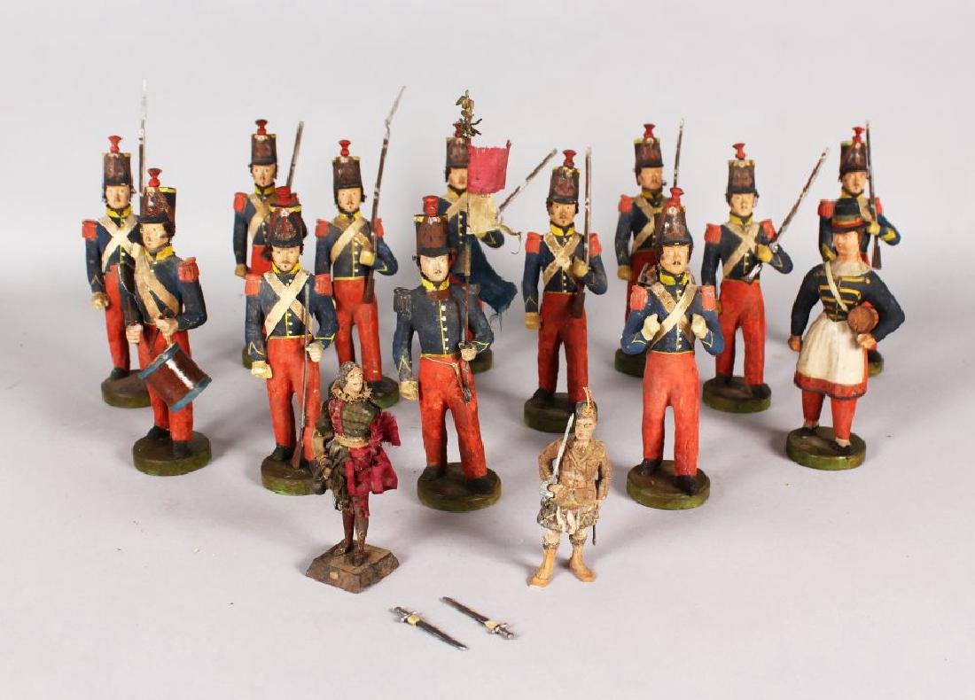 A RARE SET OF THIRTEEN CARVED AND PAINTED WOODEN: A RARE SET OF THIRTEEN CARVED AND PAINTED WOODEN PRUSSIAN SOLDIERS carrying arms, powder key and drum, and TWO SMALL LATER CARVINGS (15).