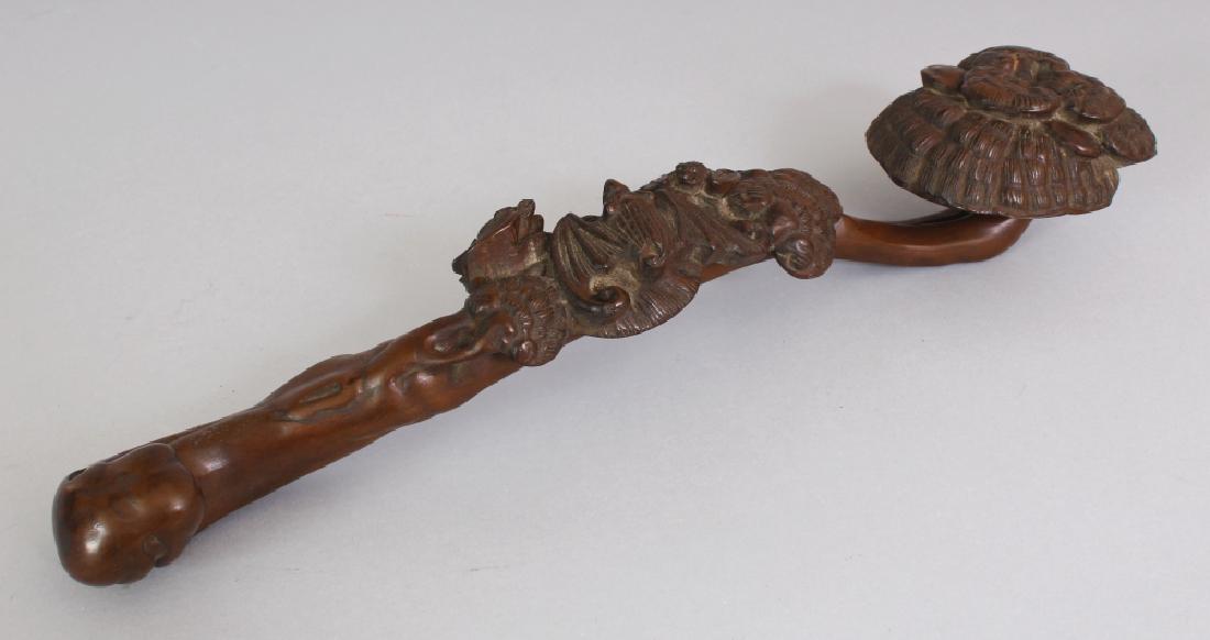 A CHINESE WOOD RUYI SCEPTRE, decorated in high relief: A CHINESE WOOD RUYI SCEPTRE, decorated in high relief with lingzhi and bats, 13.4in long.