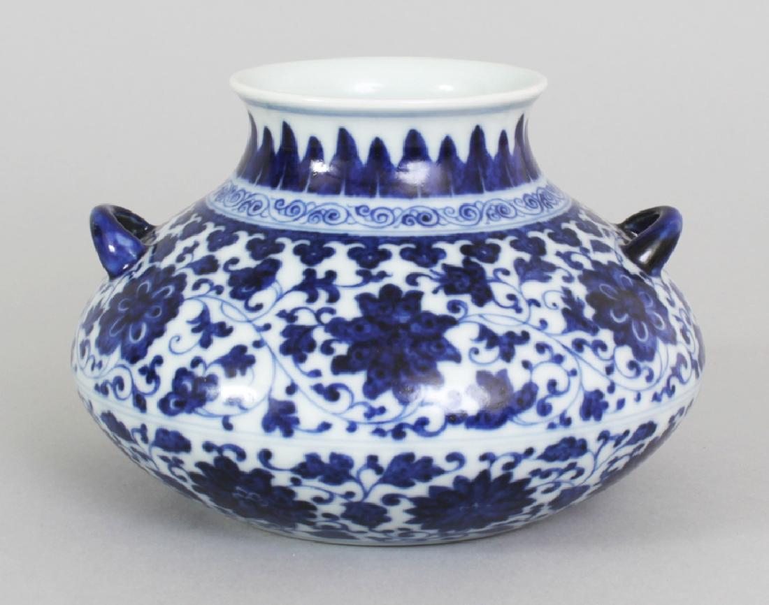 A CHINESE MING STYLE BLUE & WHITE PORCELAIN VASE, of: A CHINESE MING STYLE BLUE & WHITE PORCELAIN VASE, of unusual squat form, the sides decorated with formal scrolling foliage, the base with a Qianlong seal mark, 5.4in wide at widest point & 3.6in high.