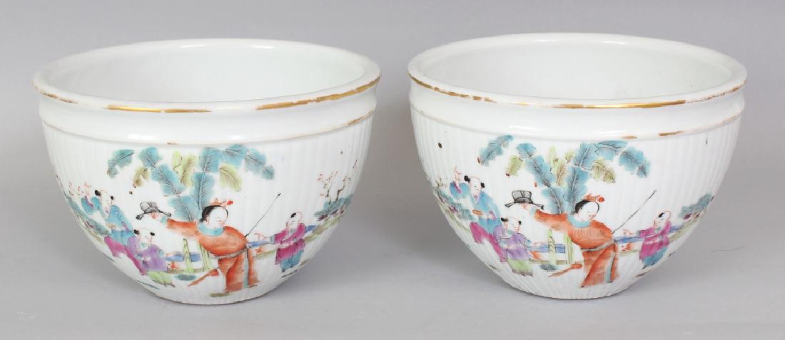 A PAIR OF CHINESE FAMILLE ROSE FLUTED PORCELAIN: A PAIR OF CHINESE FAMILLE ROSE FLUTED PORCELAIN JARDINIERES, each decorated with a continuous scene of figures in a fenced garden setting, each base with a Tongzhi seal mark, 6.6in diameter at rim & 4