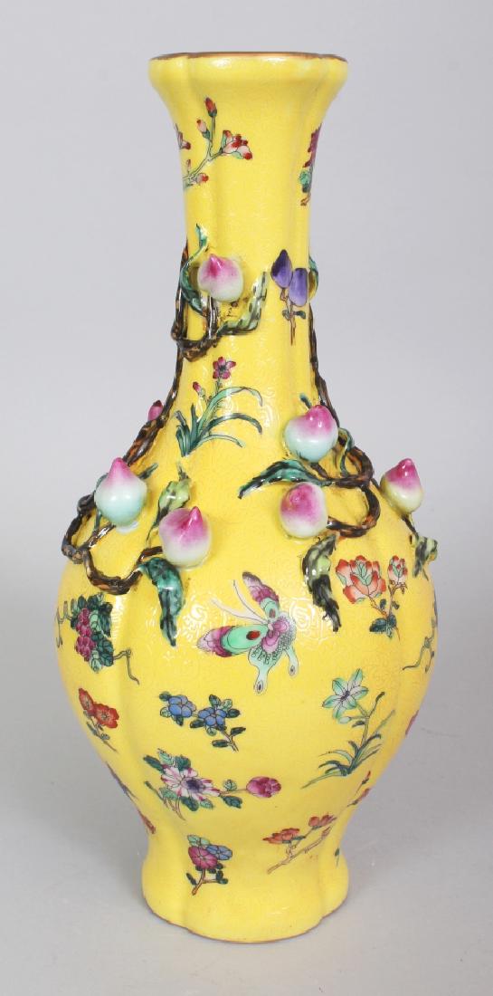 A CHINESE YELLOW GROUND FAMILLE ROSE NINE PEACH: A CHINESE YELLOW GROUND FAMILLE ROSE NINE PEACH PORCELAIN VASE, the sides moulded in high relief with branches of peach reserved on a sgraffiato ground, the base with a Qianlong seal mark, 12.25in hig