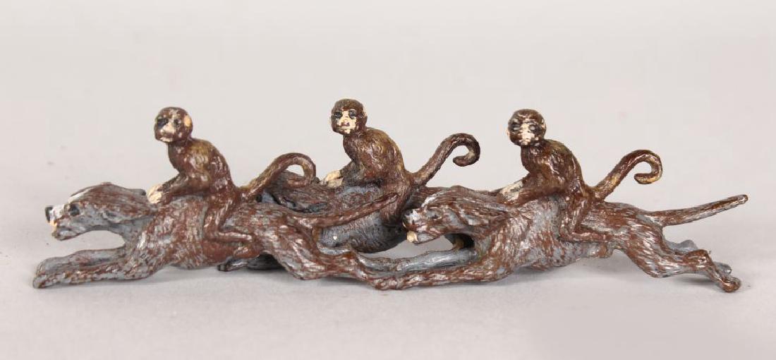 A PAINTED BRONZE COLD CAST GROUP OF THREE MONKEYS: A PAINTED BRONZE COLD CAST GROUP OF THREE MONKEYS RIDING DOGS. 5ins long.