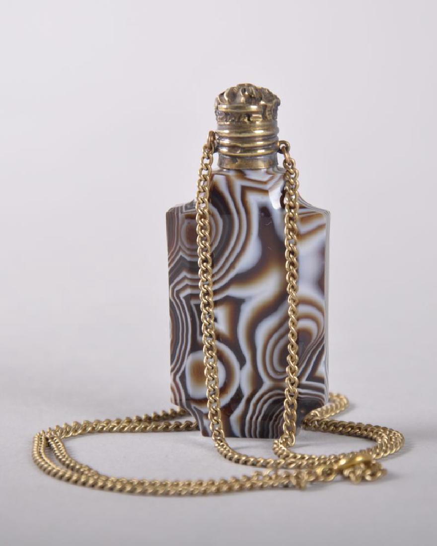 A FLAT AGATE PERFUME BOTTLE with silver cap and chain,