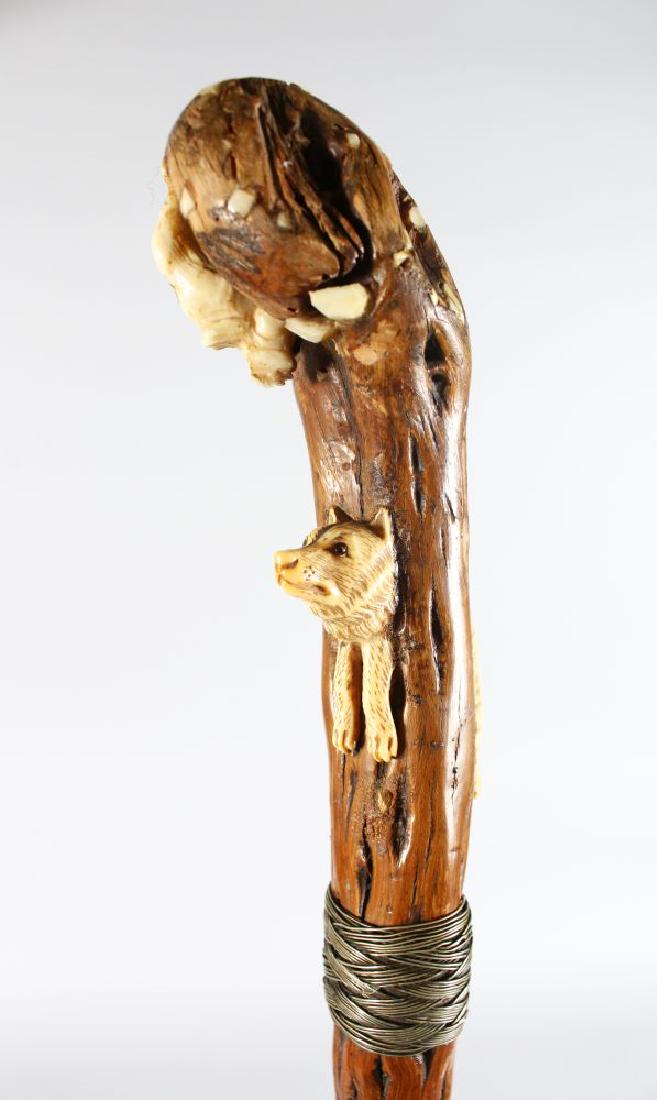 A WALKING STICK with carved wooden WOLF AND CAT handle. (1 of 2)