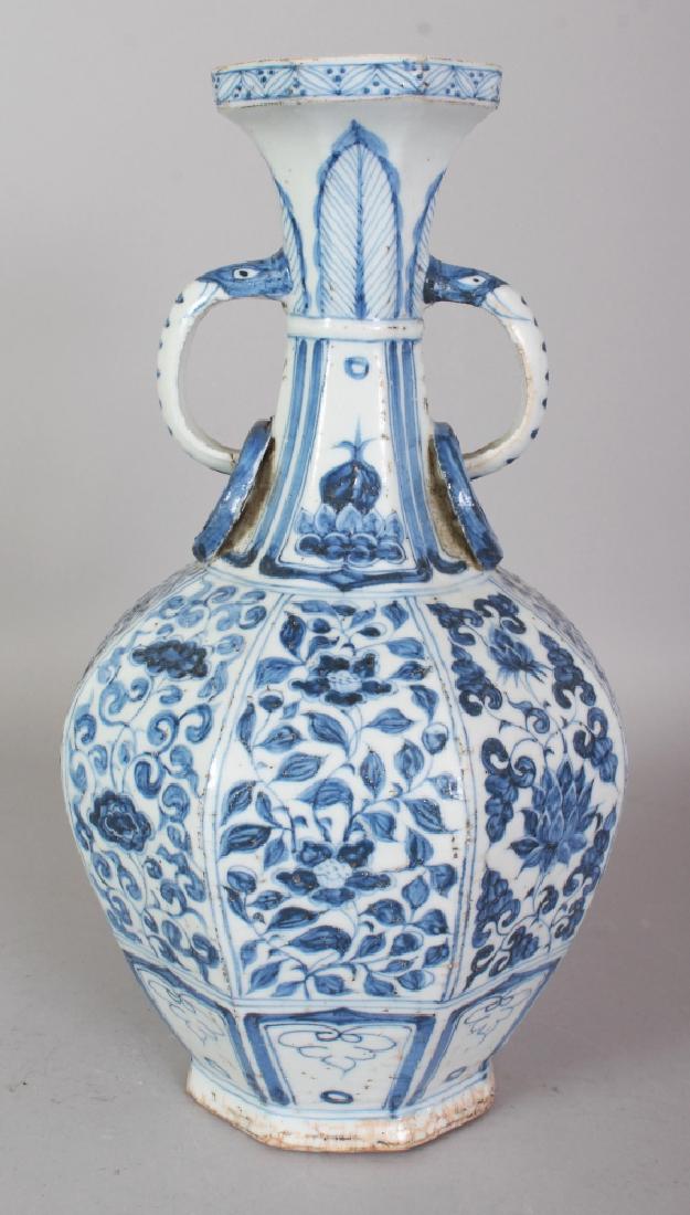 A CHINESE YUAN STYLE BLUE & WHITE OCTAGONAL SECTION: A CHINESE YUAN STYLE BLUE & WHITE OCTAGONAL SECTION PORCELAIN VASE, with moulded ring handles, the base unglazed, 13.25in high.
