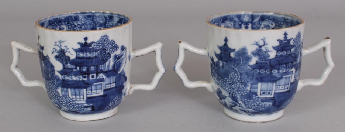 A PAIR OF 18TH CENTURY CHINESE QIANLONG PERIOD BLUE &: A PAIR OF 18TH CENTURY CHINESE QIANLONG PERIOD BLUE & WHITE TWO-HANDLED FLUTED PORCELAIN CUPS, each painted with a river landscape scene, 4.6in wide including handles & 2.6in diameter at rim & 2.7in h