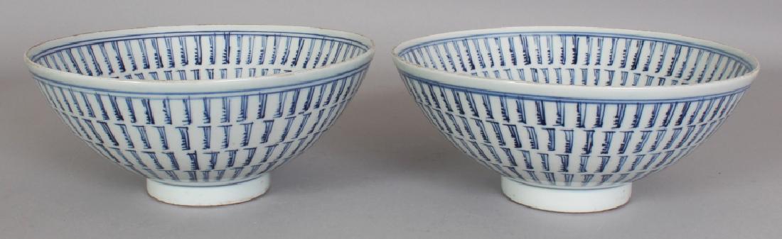 A NEAR PAIR OF CHINESE BLUE & WHITE PROVINCIAL STYLE: A NEAR PAIR OF CHINESE BLUE & WHITE PROVINCIAL STYLE PORCELAIN SHOU BOWLS, each decorated to its interior centre with an auspicious design, each base with a stylised seal mark, 8.3in diameter & 3.7in