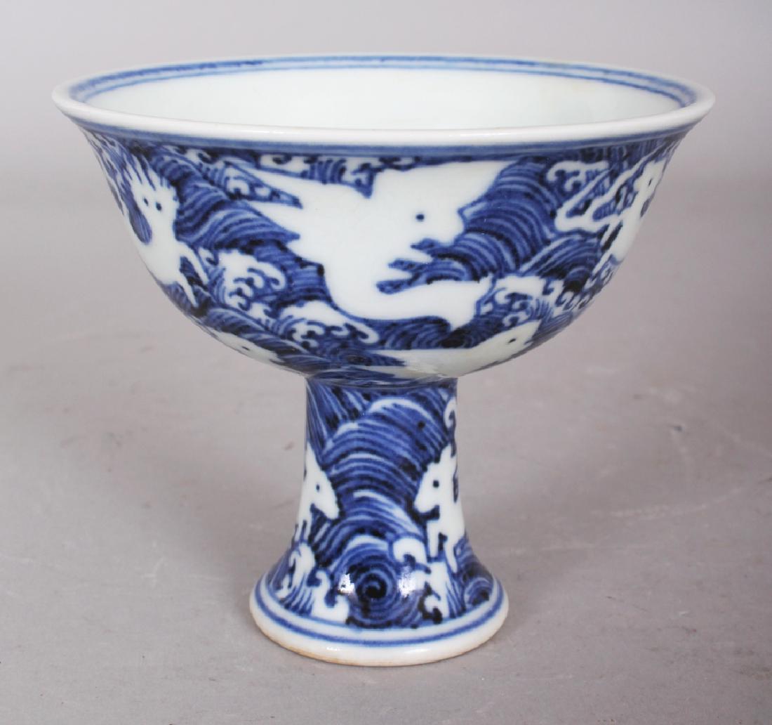 A CHINESE MING STYLE BLUE & WHITE PORCELAIN STEM BOWL,: A CHINESE MING STYLE BLUE & WHITE PORCELAIN STEM BOWL, decorated with mythical animals reserved on a wave ground, the base unglazed, the interior centre with a six-character Xuande mark, 4in diameter 