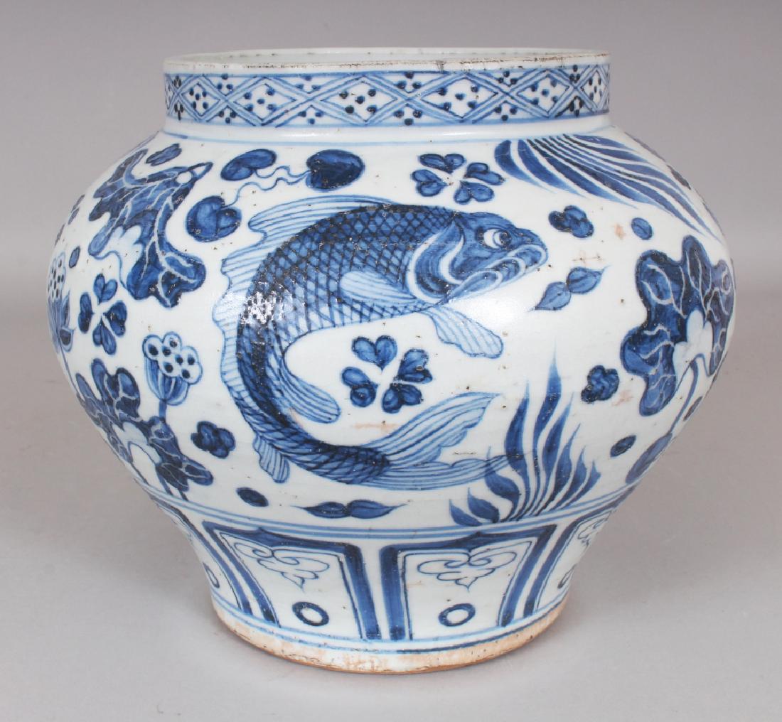 A CHINESE YUAN STYLE BLUE & WHITE PORCELAIN CARP JAR,: A CHINESE YUAN STYLE BLUE & WHITE PORCELAIN CARP JAR, the base unglazed, 9.4in wide at widest point & 8in high.