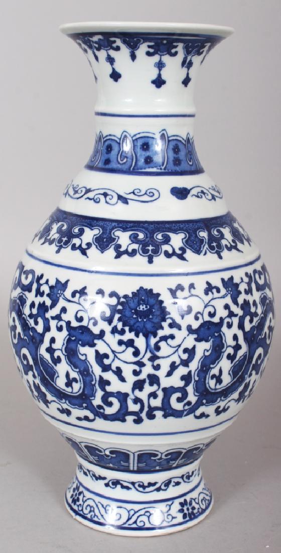 A CHINESE MING STYLE BLUE & WHITE PORCELAIN VASE, the: A CHINESE MING STYLE BLUE & WHITE PORCELAIN VASE, the sides with archaic confronting dragons, the base with a Qianlong seal mark, 10.1in high.