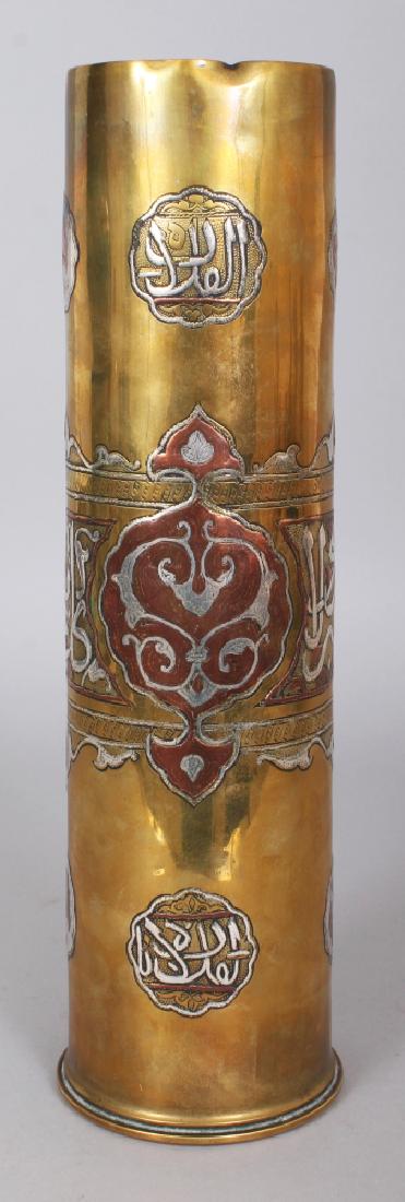 AN UNUSUAL EARLY/MID 20TH CENTURY CAIRO WARE DECORATED: AN UNUSUAL EARLY/MID 20TH CENTURY CAIRO WARE DECORATED ARTILLERY SHELL CASE, decorated in silver-metal and copper with cartouches and script, 12.25in high.