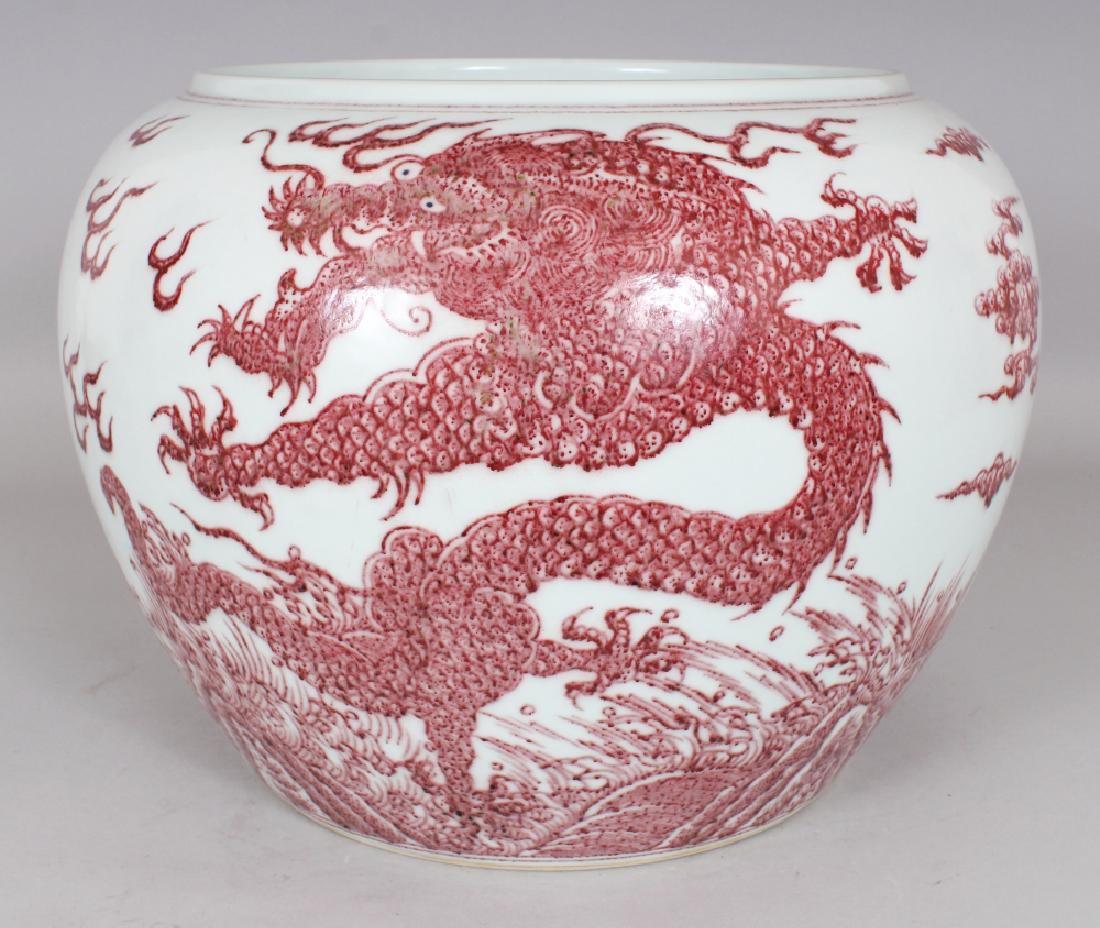 A LARGE CHINESE MING STYLE COPPER RED PORCELAIN DRAGON: A LARGE CHINESE MING STYLE COPPER RED PORCELAIN DRAGON JARDINIERE, the base with a six-character Kangxi mark, 13.5in wide at widest point & 10in high.