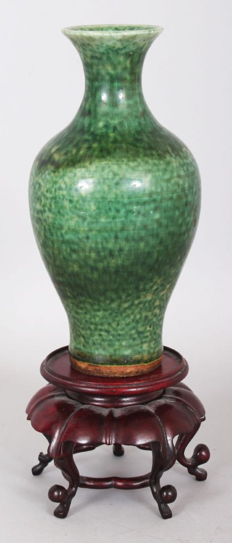 A GOOD 18TH/19TH CENTURY CHINESE GREEN GLAZED BALUSTER: A GOOD 18TH/19TH CENTURY CHINESE GREEN GLAZED BALUSTER PORCELAIN VASE, together with a wood stand, the sides of the vase applied with a mottled glaze, the vase itself 6.8in high.