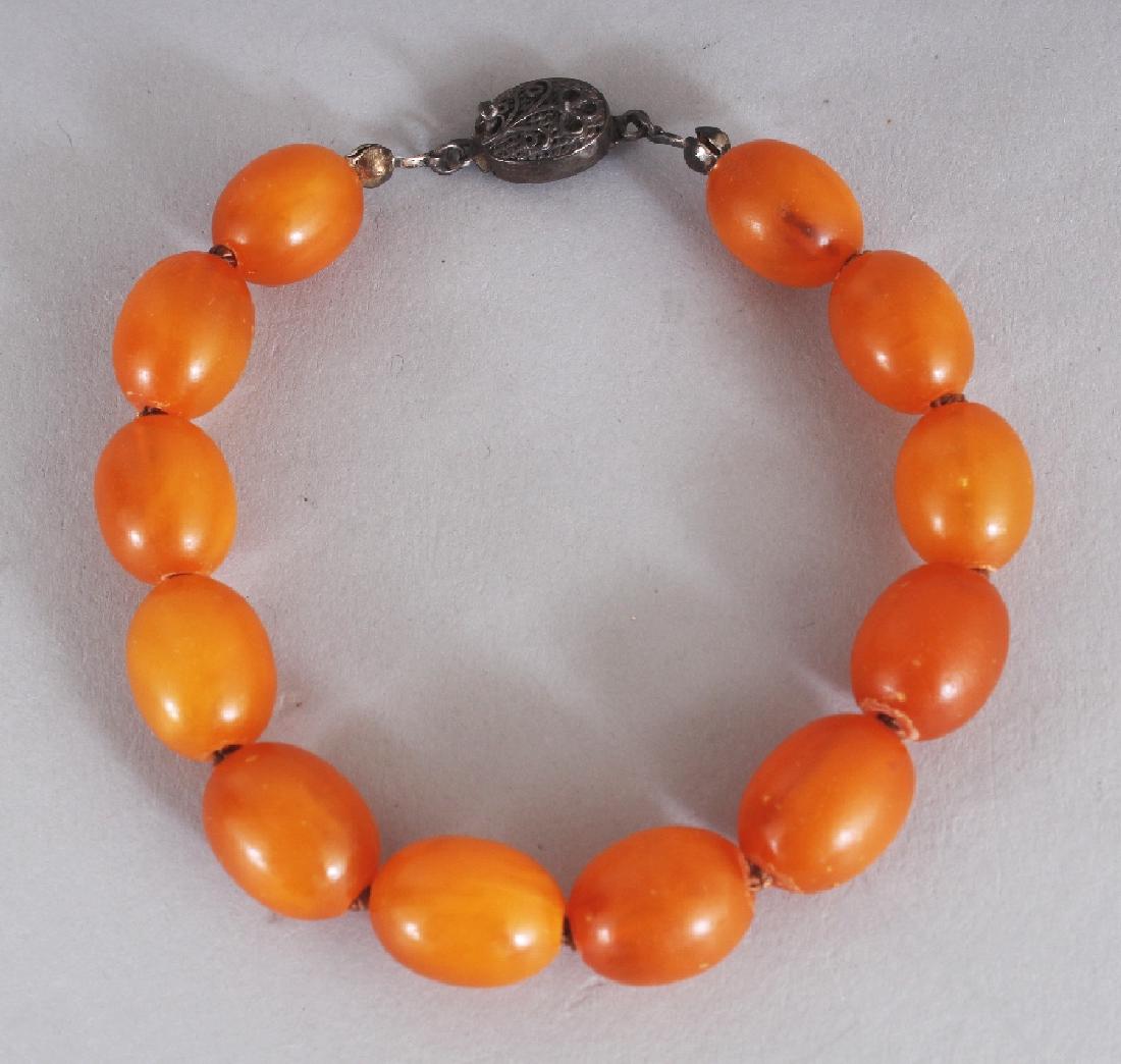 AN AMBER BRACELET, with a silver metal clasp, weighing (1 of 3)