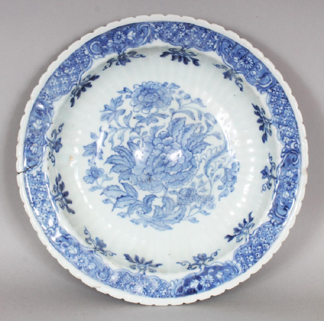AN UNUSUAL EARLY 18TH CENTURY CHINESE BLUE & WHITE: AN UNUSUAL EARLY 18TH CENTURY CHINESE BLUE & WHITE FLUTED PORCELAIN DISH, the domed interior painted with peony and leafage, 9.1in diameter.