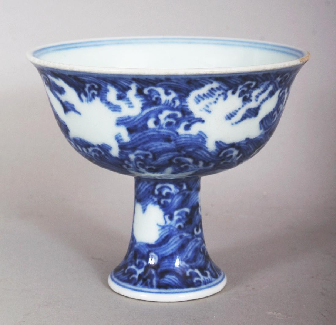 A CHINESE MING STYLE BLUE & WHITE PORCELAIN STEM BOWL,: A CHINESE MING STYLE BLUE & WHITE PORCELAIN STEM BOWL, the sides decorated with mythical animals reserved in white against a ground of swirling waves, the base unglazed, the interior centre with a six