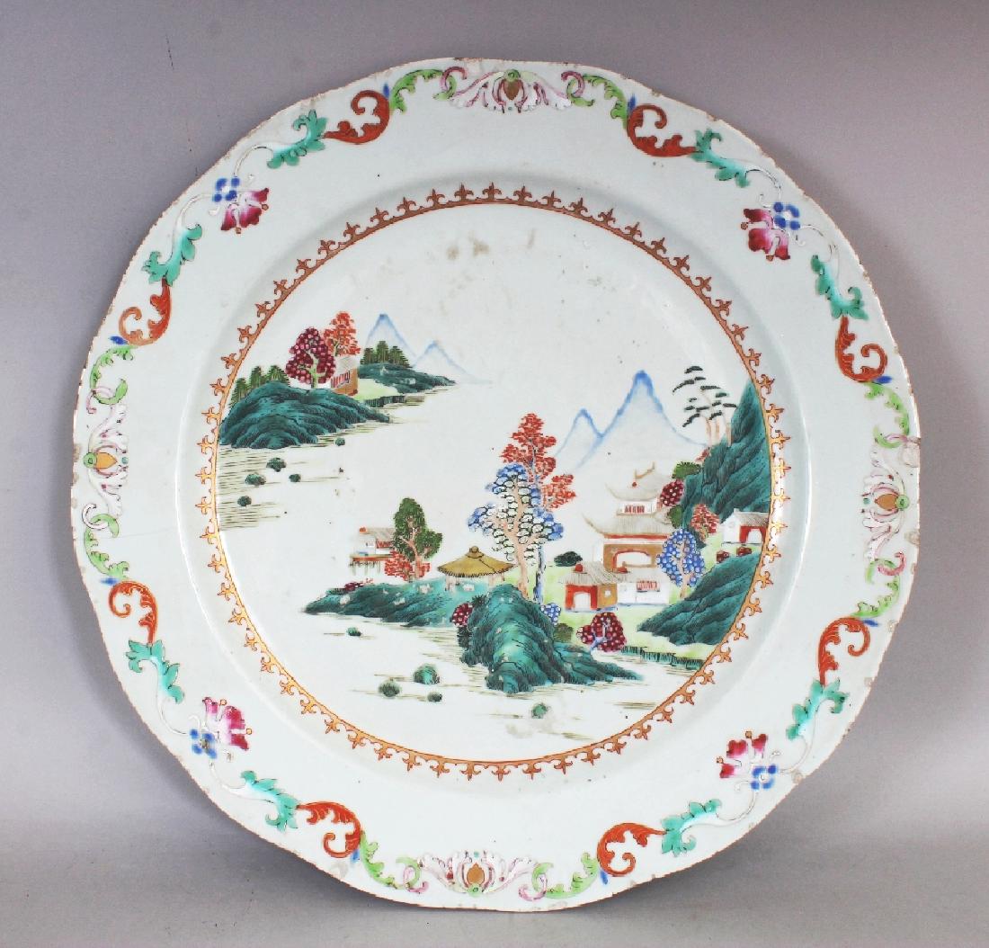 A LARGE 18TH CENTURY CHINESE QIANLONG PERIOD FAMILLE: A LARGE 18TH CENTURY CHINESE QIANLONG PERIOD FAMILLE ROSE PORCELAIN DISH, painted to its centre with a river landscape scene, 15in diameter.