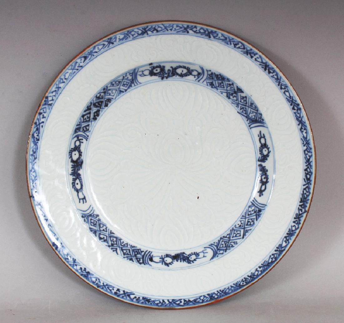 A CHINESE YONGZHENG PERIOD BLUE & WHITE MOULDED: A CHINESE YONGZHENG PERIOD BLUE & WHITE MOULDED PORCELAIN PLATE, circa 1730, decorated beneath the glaze with lotus, 8.8in diameter.