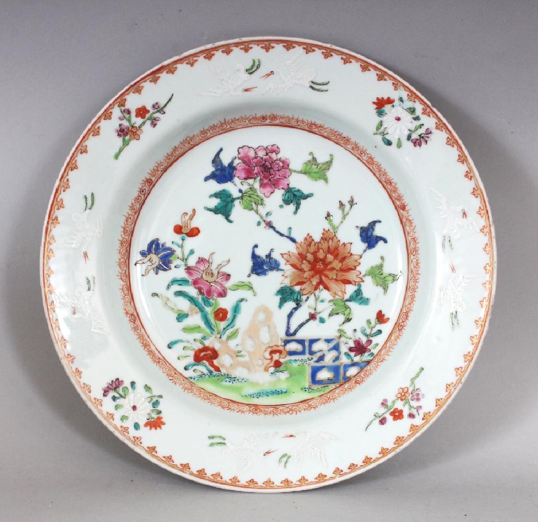 AN 18TH CENTURY CHINESE QIANLONG PERIOD FAMILLE ROSE: AN 18TH CENTURY CHINESE QIANLONG PERIOD FAMILLE ROSE PORCELAIN SOUP PLATE, painted to its interior with a garden scene, the rim with storks, 8.9in diameter.