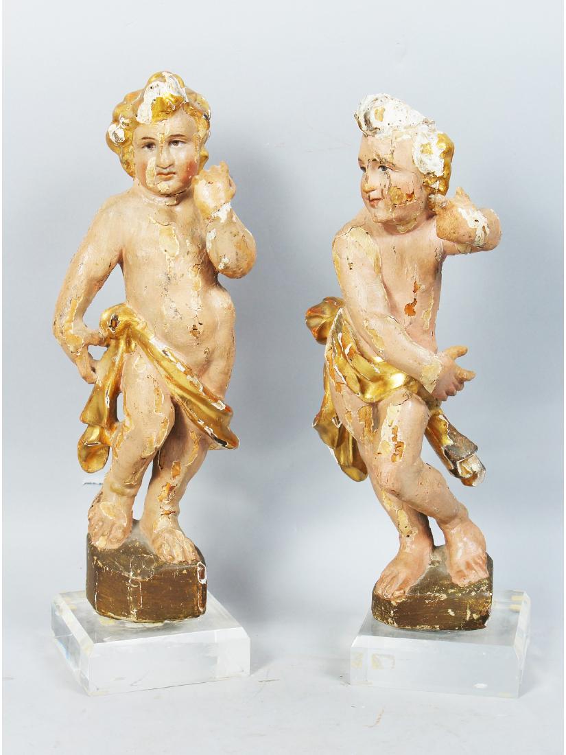 A PAIR OF 18TH CENTURY ITALIAN CARVED WOOD, PAINTED AND: A PAIR OF 18TH CENTURY ITALIAN CARVED WOOD, PAINTED AND GILDED STANDING CUPIDS on Perspex bases. 15ins high.