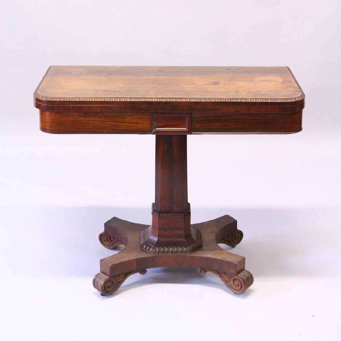 A REGENCY ROSEWOOD FOLD-OVER CARD TABLE, with rounded: A REGENCY ROSEWOOD FOLD-OVER CARD TABLE, with rounded rectangular top, chamfered column support on a concave sided base with scroll feet. 3ft 0ins wide x 2ft 5ins high x 1ft 6ins deep.