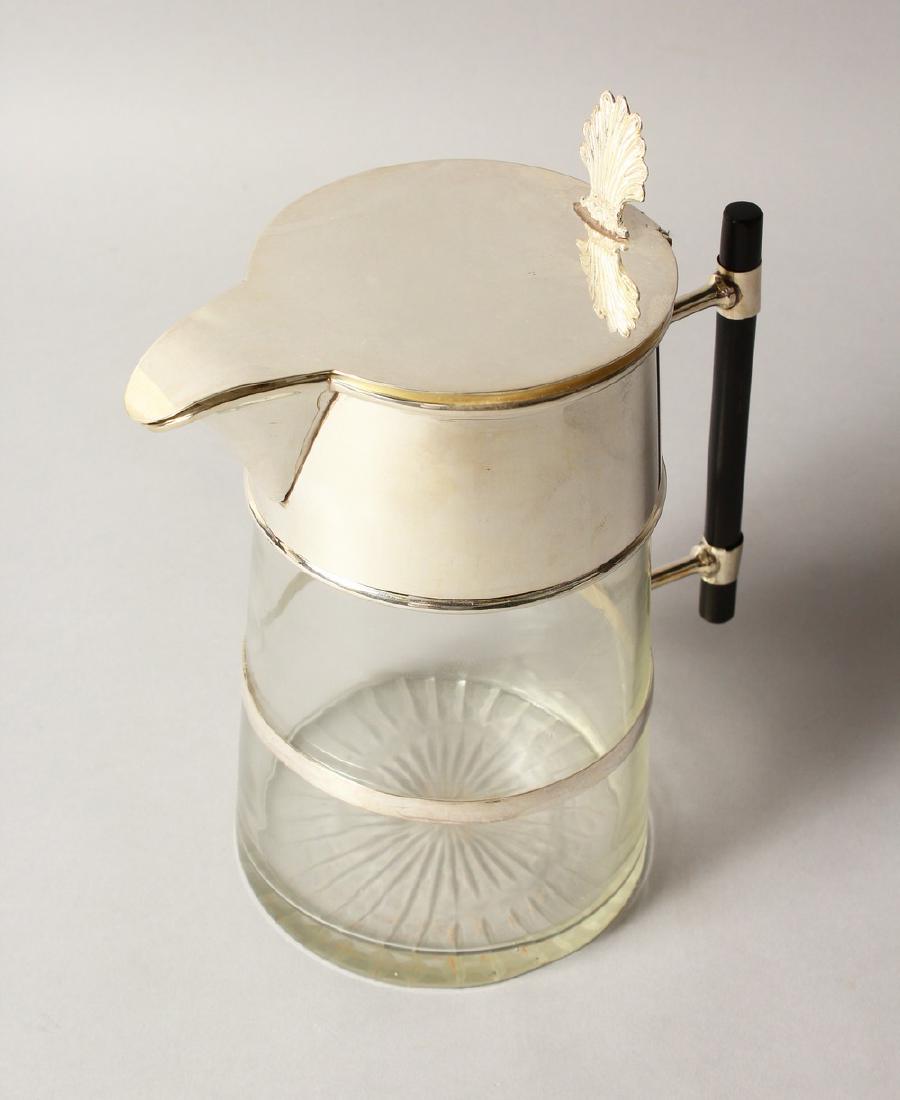 A CHRISTOPHER DRESSER DESIGN GLASS LEMONADE JUG with: A CHRISTOPHER DRESSER DESIGN GLASS LEMONADE JUG with plated lid and ebony handle.