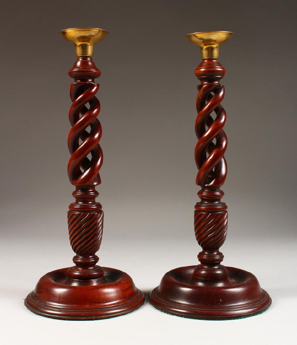 A PAIR OF TURNED WOOD CANDLESTICKS. 12ins high.