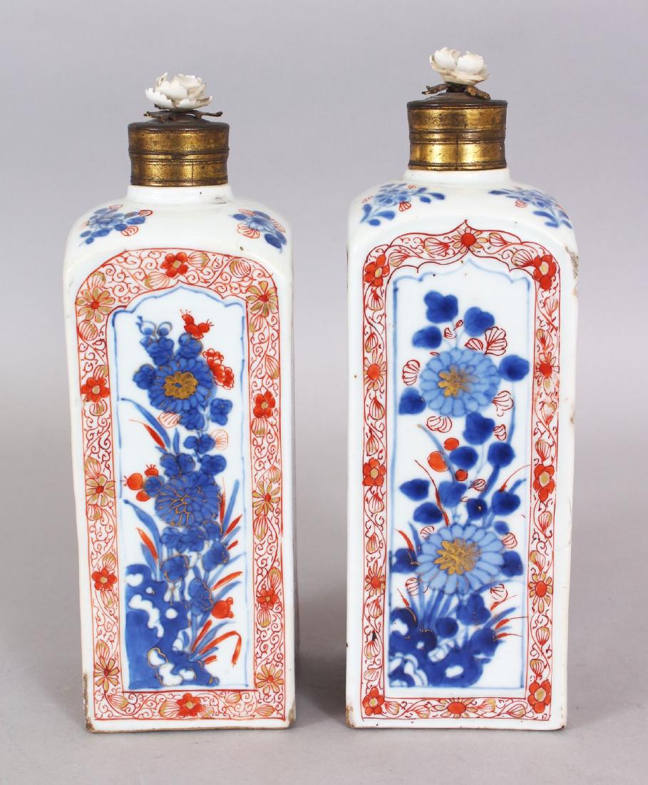 A GOOD PAIR OF LATE 17TH CENTURY CHINESE IMARI SQUARE: A GOOD PAIR OF LATE 17TH CENTURY CHINESE IMARI SQUARE SECTION PORCELAIN FLASKS, the sides painted with alternating landscape and foliate panels, each with a metal cover incorporating a porcelain flowe