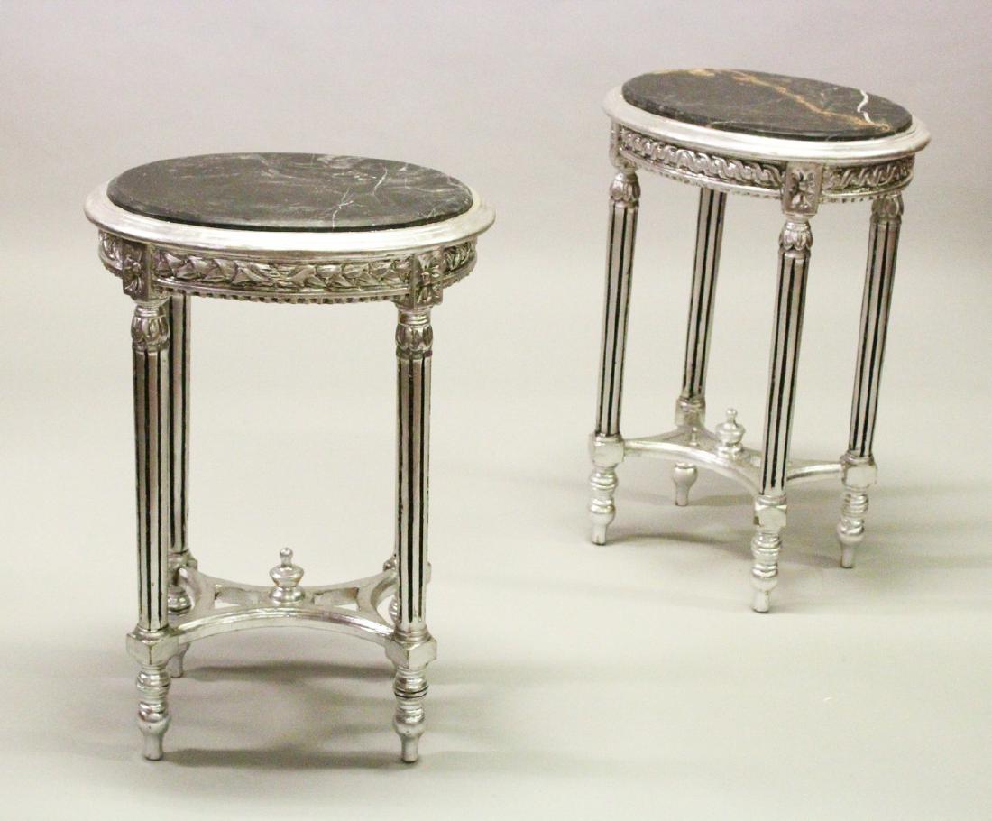 A PAIR OF SILVERED OVAL TABLES, with inset marble tops, (1 of 3)