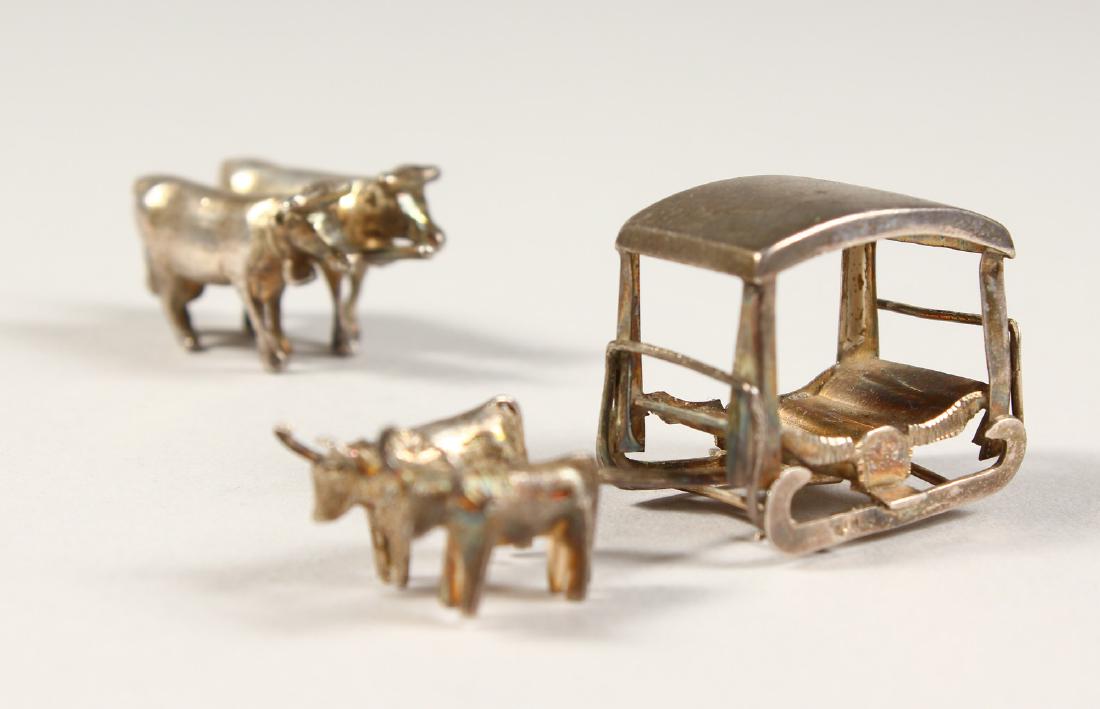 A SMALL SILVER GROUP OF TWO OXEN pulling a cart, and (1 of 5)
