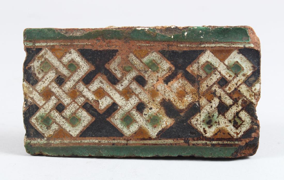 A 14TH CENTURY SPANISH POTTERY ISLAMIC BORDER TILE,: A 14TH CENTURY SPANISH POTTERY ISLAMIC BORDER TILE, 14cm long, 7.5cm wide.