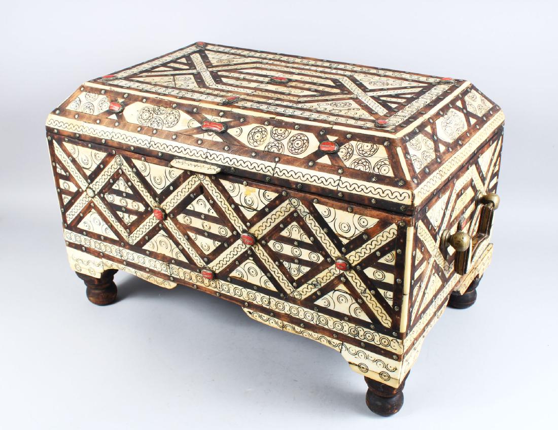 A LARGE 19TH CENTURY MOROCCAN ISLAMIC INLAID BONE AND: A LARGE 19TH CENTURY MOROCCAN ISLAMIC INLAID BONE AND CORAL CASKET, with brass carrying handles on bun feet, 56cm long, 34cm wide, 36cm high.
