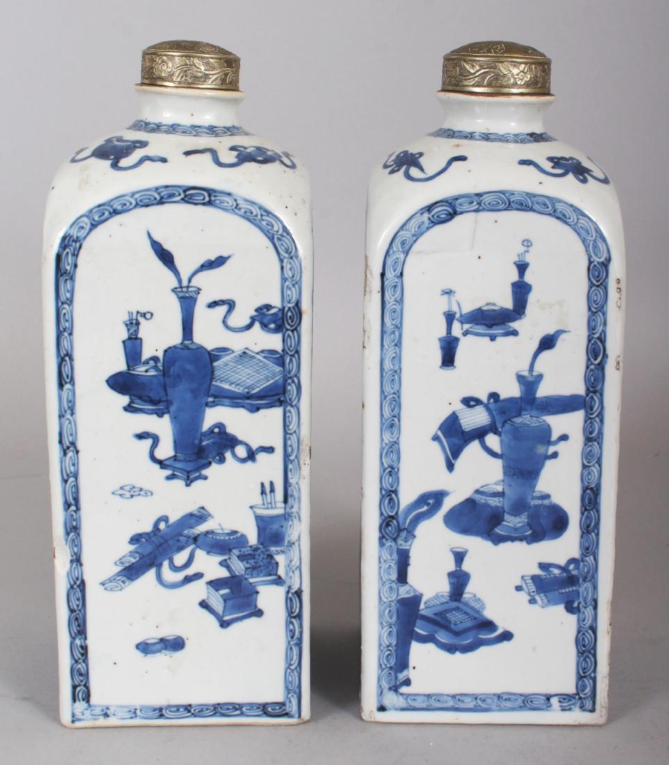 A GOOD PAIR OF LATE 17TH CENTURY CHINESE BLUE & WHITE: A GOOD PAIR OF LATE 17TH CENTURY CHINESE BLUE & WHITE SQUARE SECTION PORCELAIN FLASKS, with rounded shoulders and silvered metal covers, each painted with alternating panels of extended foliage and of